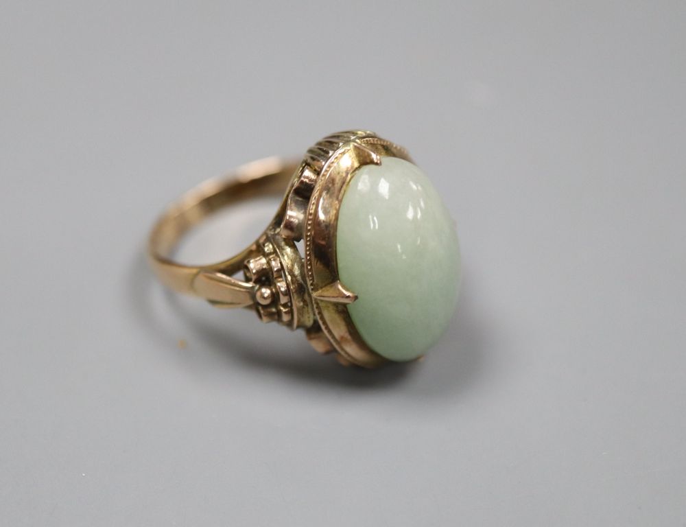 A 14k yellow metal and oval cabochon jade set ring, size L/M, gross 5 grams.
